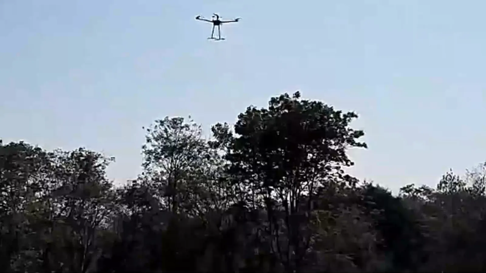 Counter-drone interceptor in flight above trees