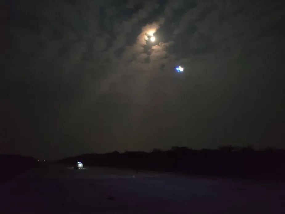 Target tracking drone with lights on, flying at night